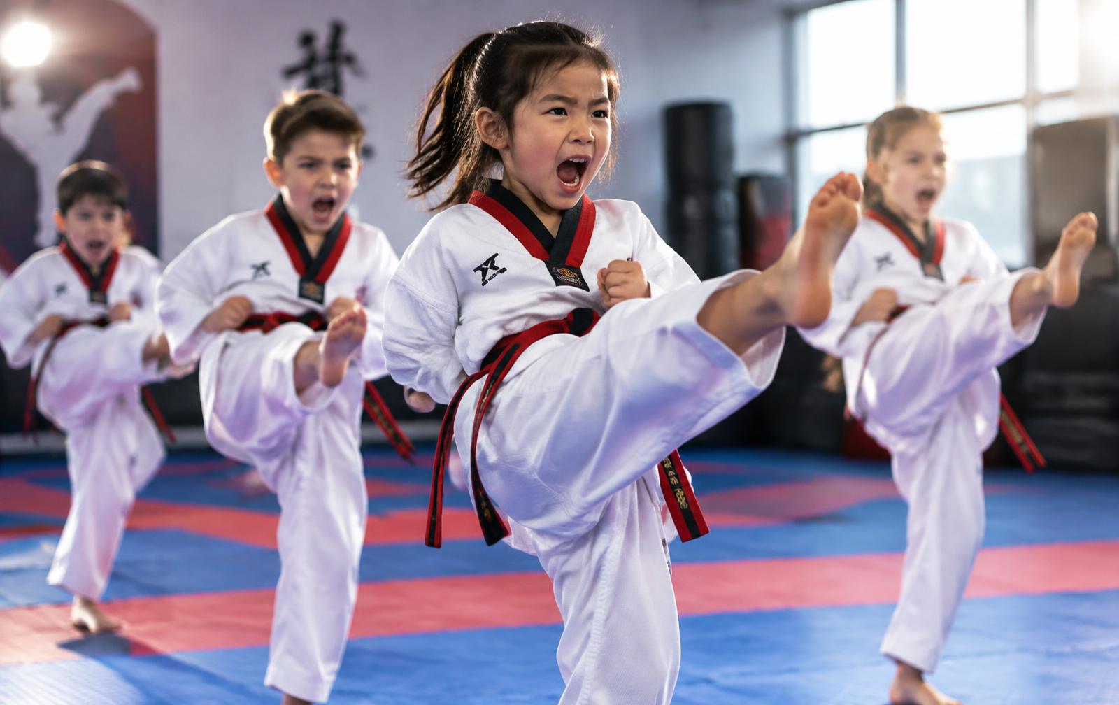 Kids practicing kicks in taekwondo class